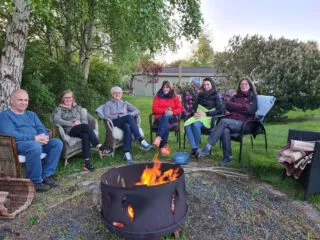Kolleginnen und Kollegen sitzen bei der Dänemark-Reise 2022 gemeinsam an einer Feuerschale